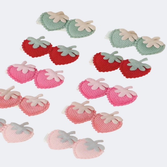 Decorative strawberry-shaped items in red, pink, and green on a beige background.