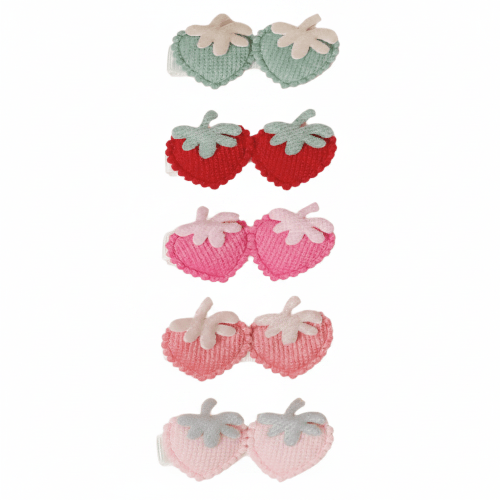 Set of strawberry-shaped hair clips in red, pink, and green on a white background