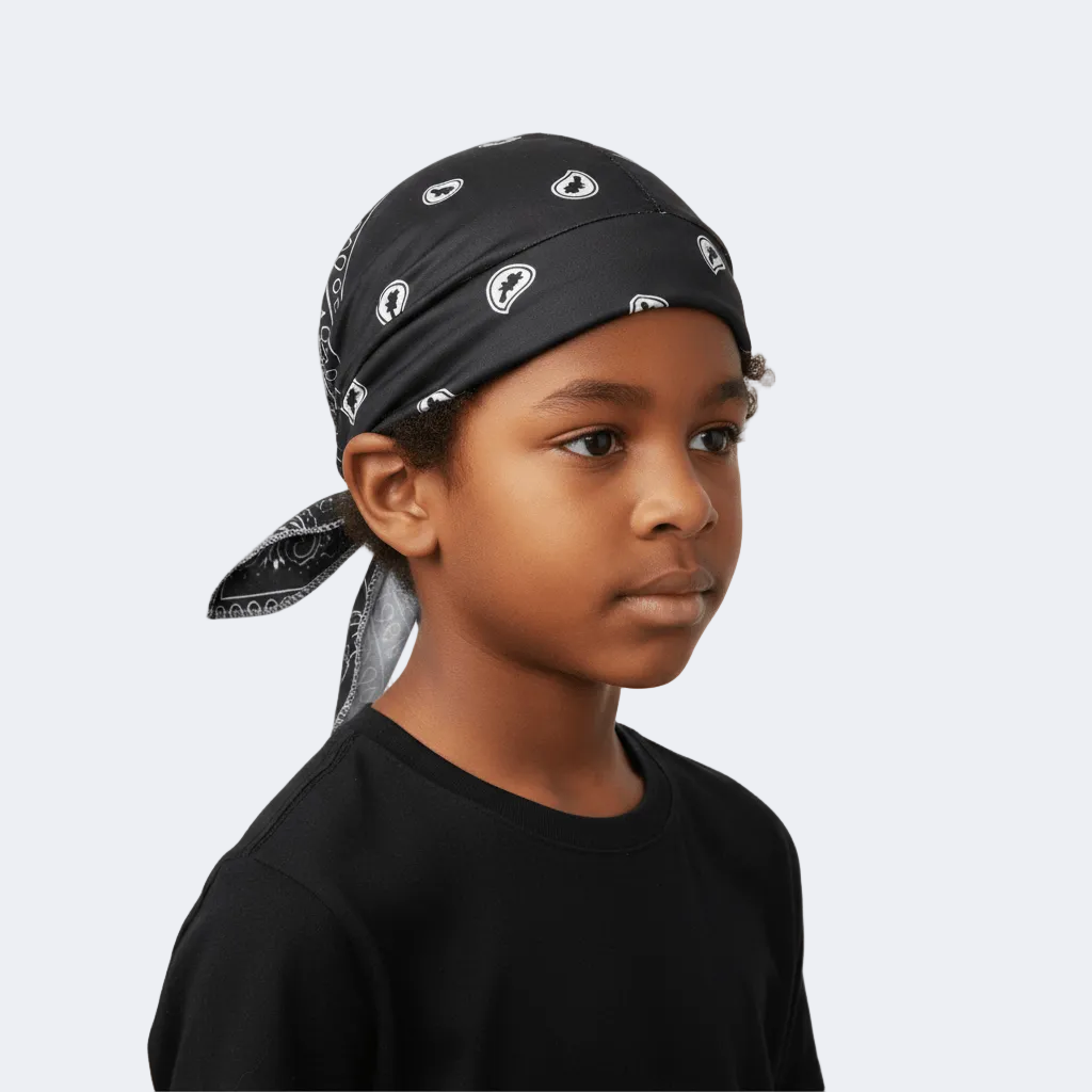 Child wearing a black bandana with white patterns on a plain background