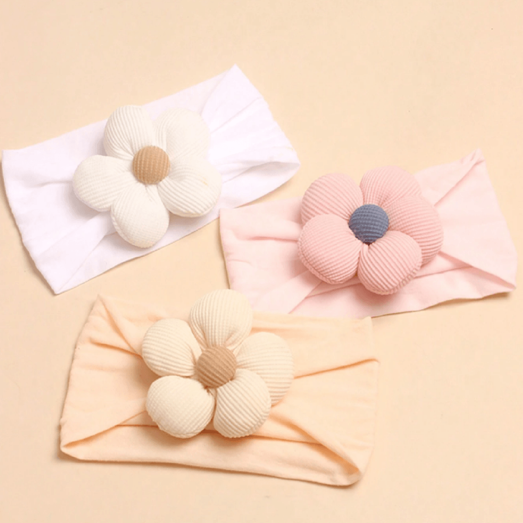 Three headbands with floral designs on a beige background
