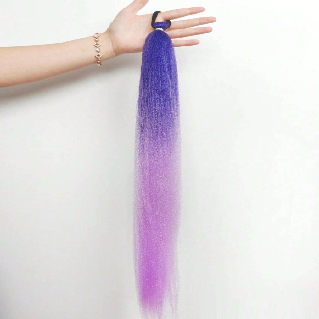 Purple hair extension held by a hand on a white background