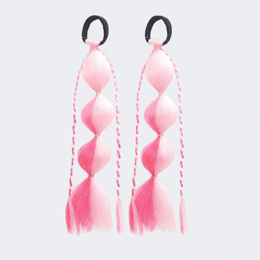 Pink hair ties with black elastic bands on a white background