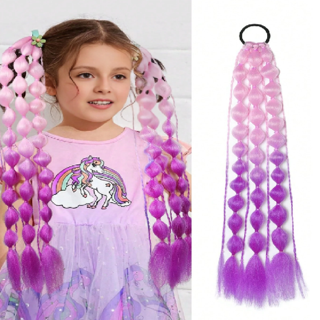 Child wearing a dress with unicorn design holding pink and purple hair extensions.
