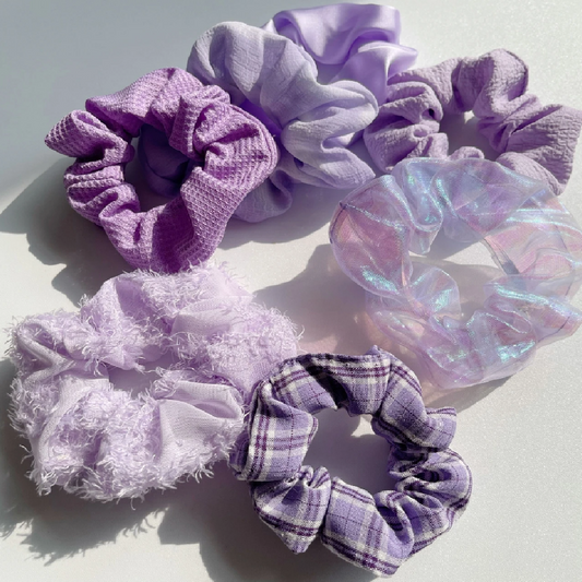 Set of purple and lavender scrunchies on a light background