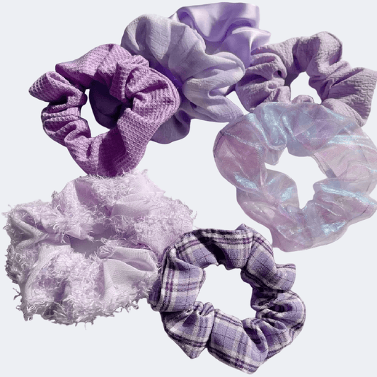 Set of purple and white scrunchies on a light purple background