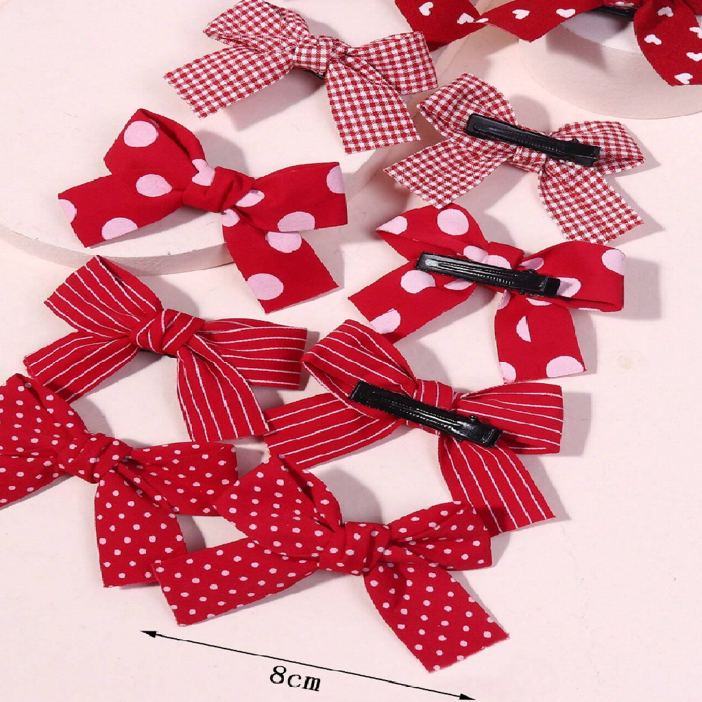 Red and white polka dot hair bows with clips on a light background