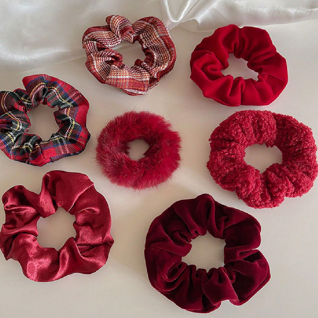 Red and plaid scrunchies on a white fabric background