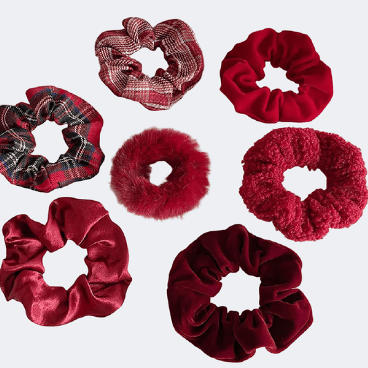 Collection of red and plaid scrunchies on a light gray background