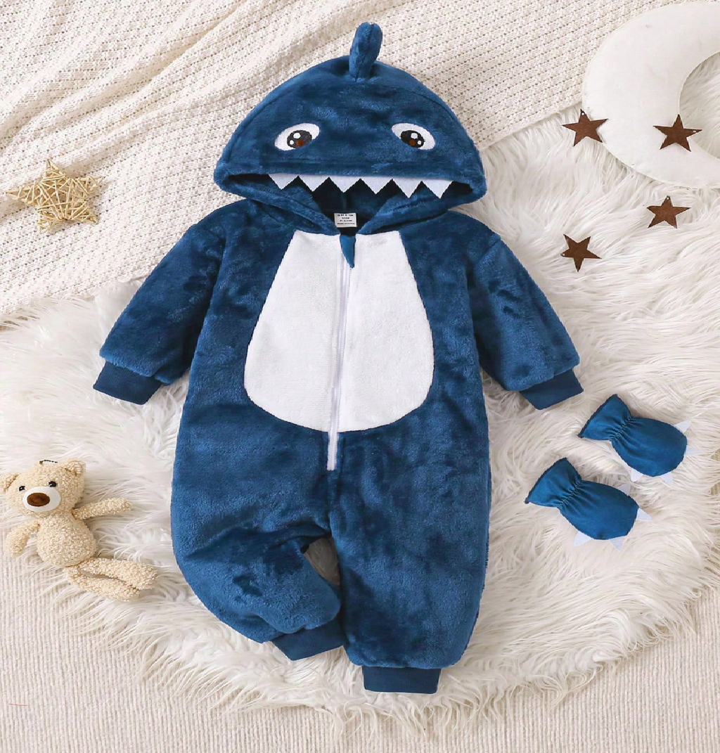 Blue shark-themed baby onesie with matching booties on a textured surface.
