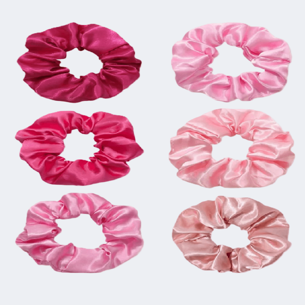 Set of six pink satin scrunchies on a white background