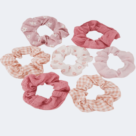 Set of pink and white scrunchies with floral and checkered patterns on a light gray background