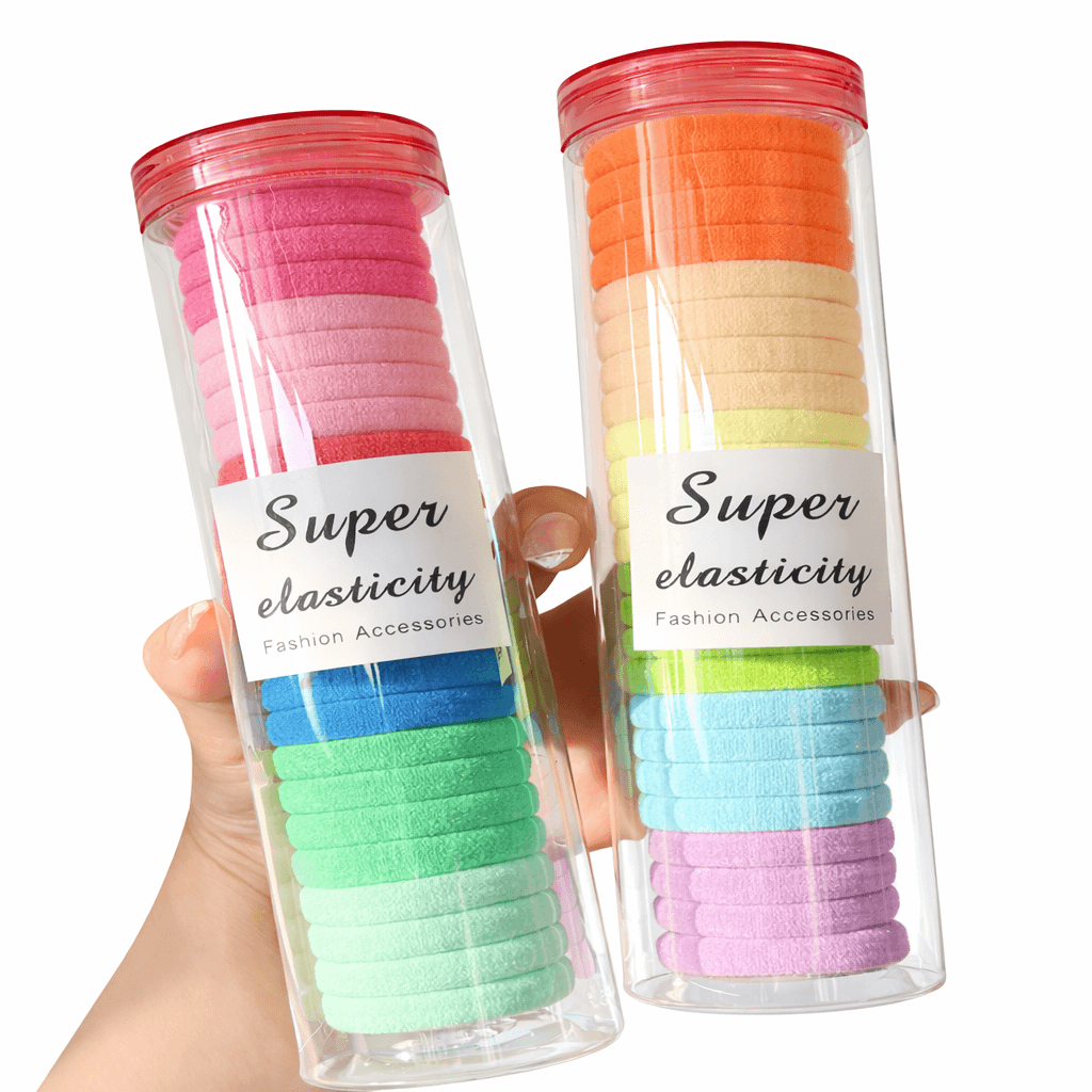Two clear cylindrical containers with colorful hair ties labeled 'Super elasticity' held by a hand.