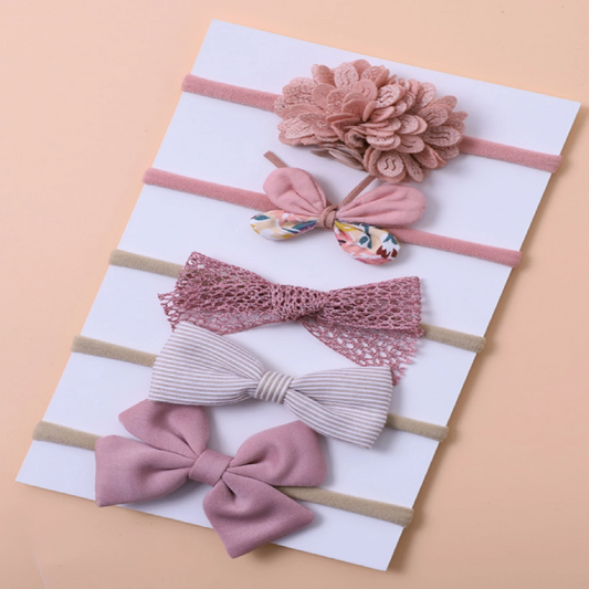 Set of pink hair accessories including bows and a headband