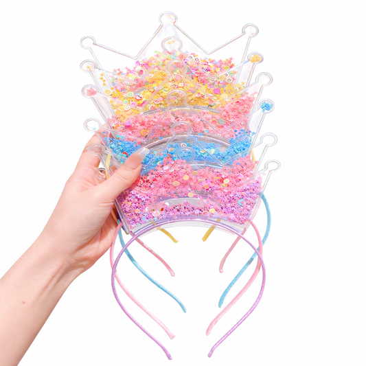 Colorful crown-shaped slime held by a hand on a white background
