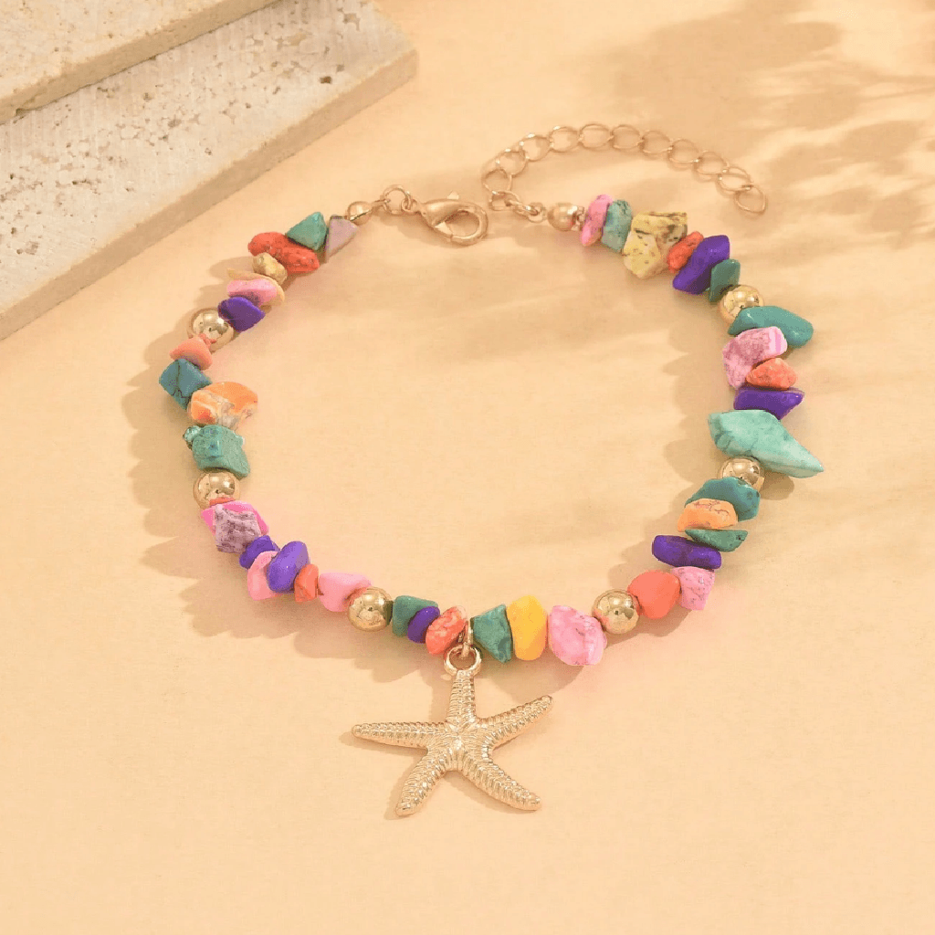 Colorful beaded bracelet with a starfish charm on a beige surface