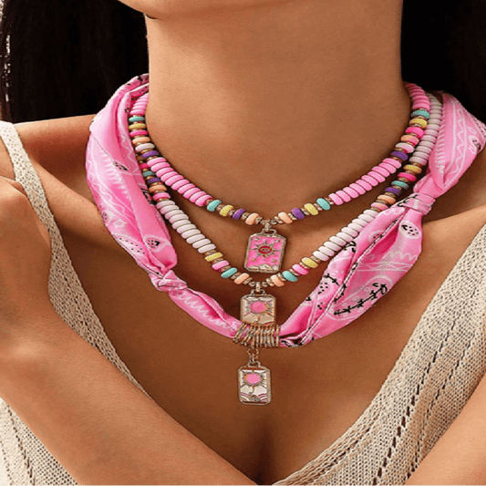Necklace with colorful beads and pink scarf worn by a person