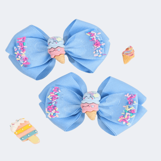 Two blue hair bows with ice cream cone decorations on a light gray background