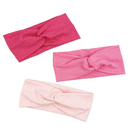Three pink knotted headbands on a white background