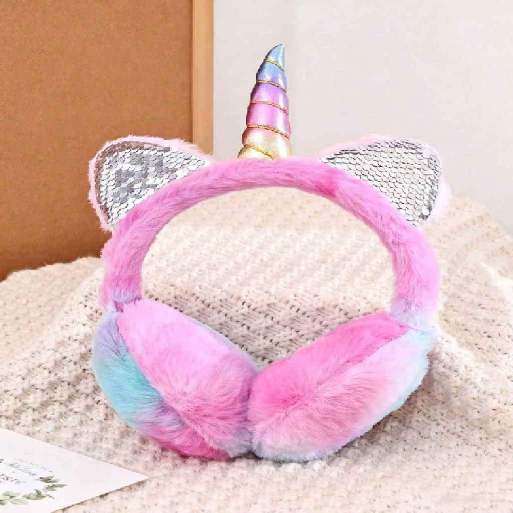 Unicorn-themed pink and blue ear muffs on a textured surface.