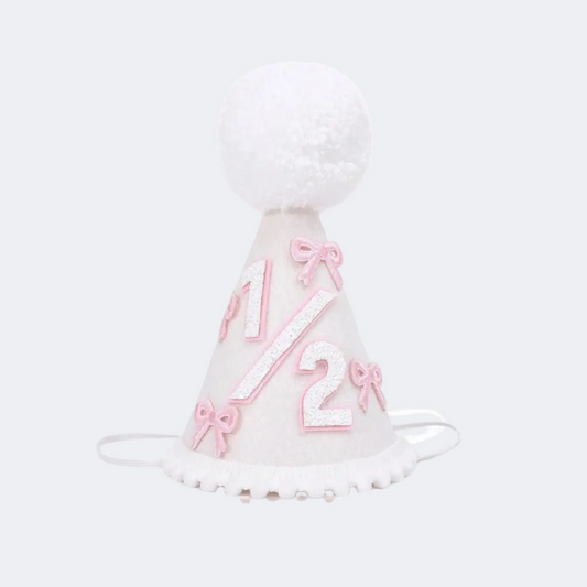White birthday hat with pink numbers and bows on a white background