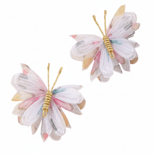 Two butterfly-shaped hair accessories with pastel colors on a white background