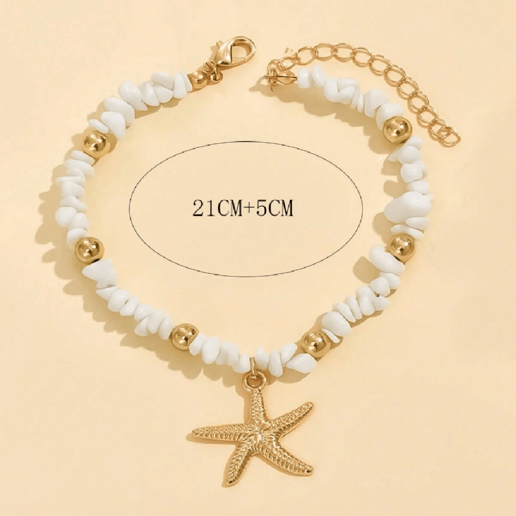 Bracelet with white beads, gold accents, and a starfish charm on a beige background