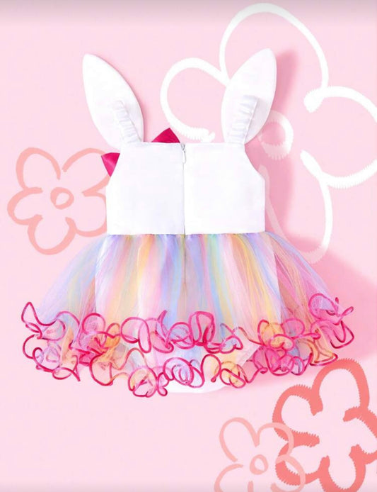 Children's dress with bunny ears and colorful skirt on a pink floral background
