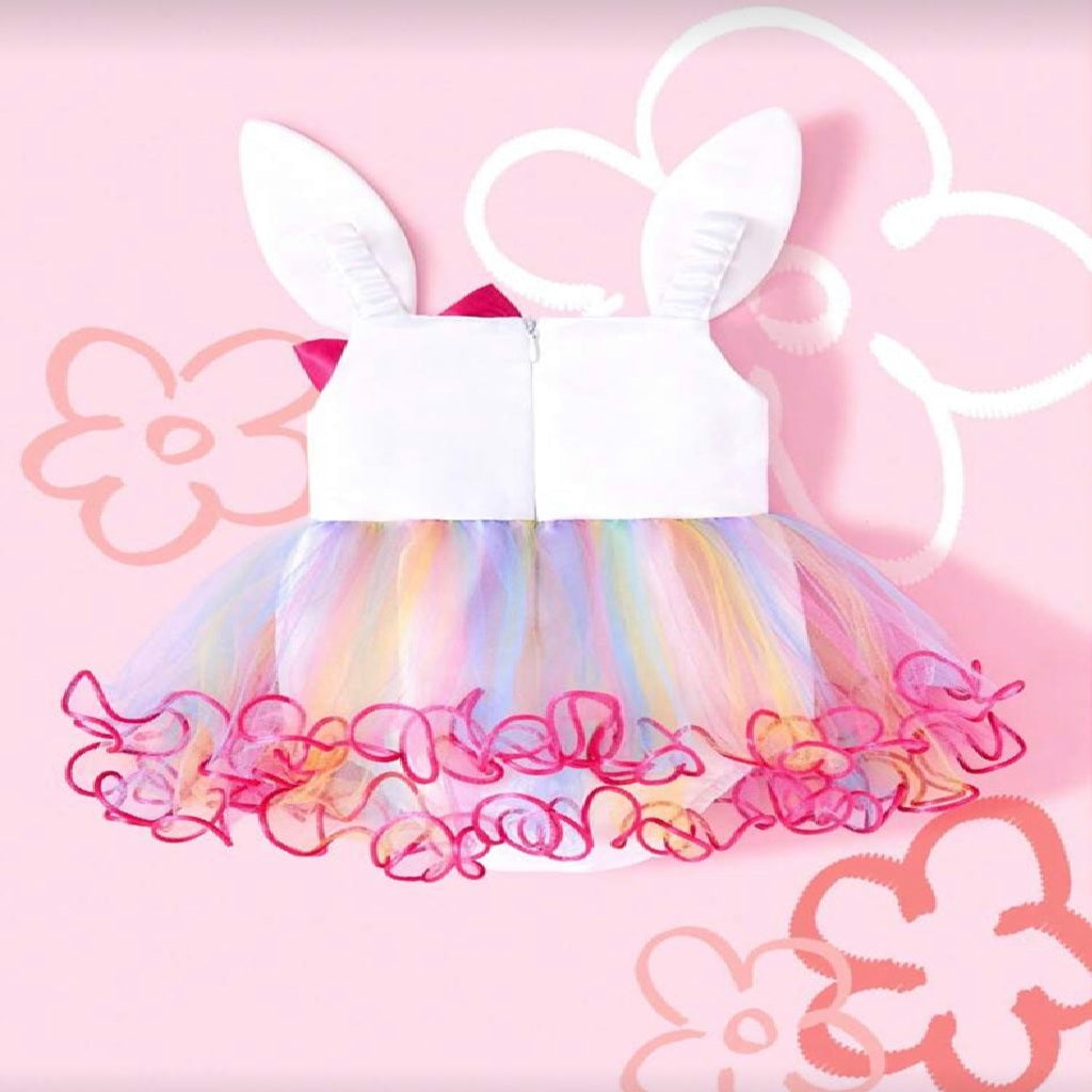 Children's dress with bunny ears and colorful skirt on a pink floral background