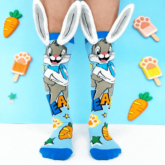 Cartoon character socks with bunny ears on a blue background with cartoon food items.