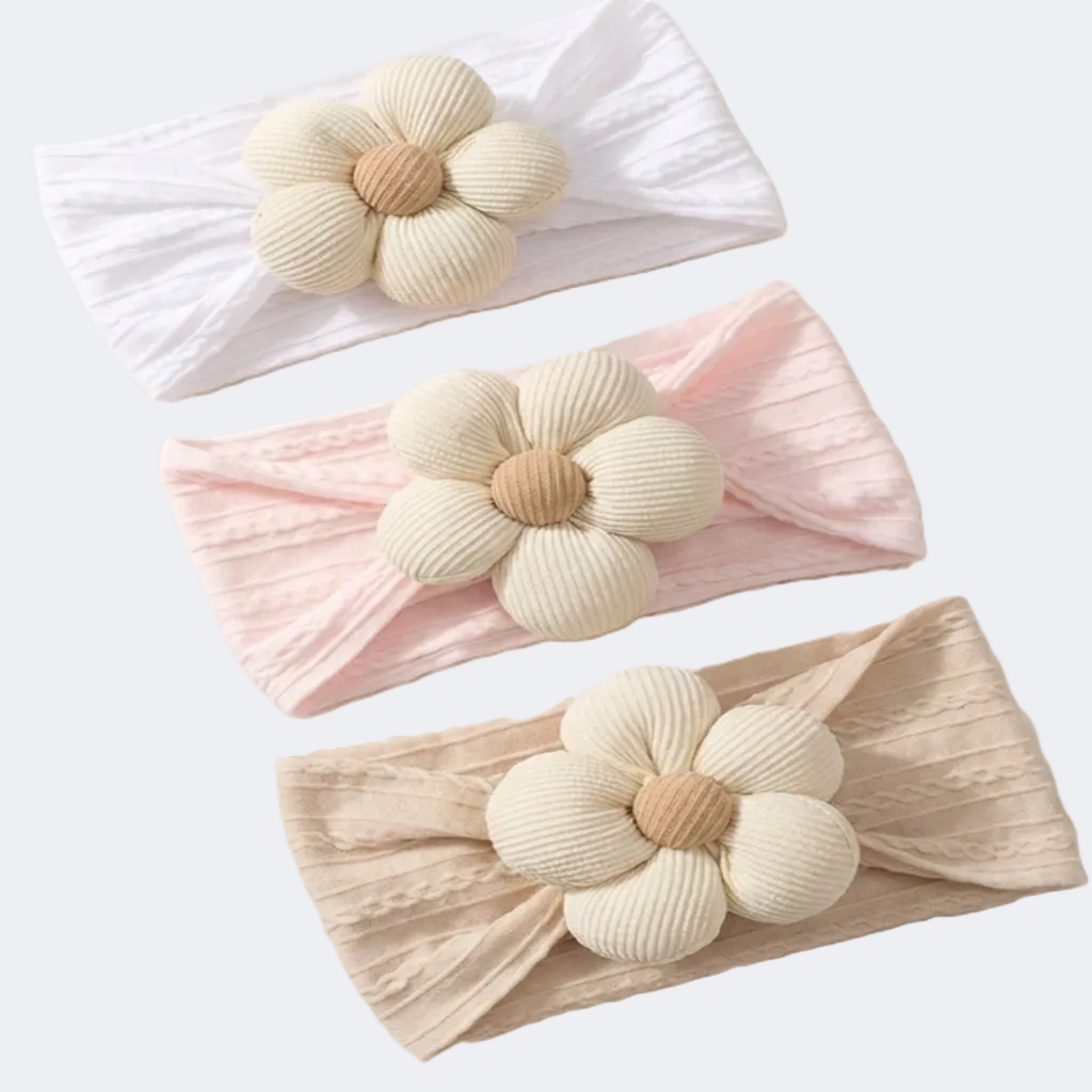 Three headbands with floral designs in white, pink, and beige on a white background.