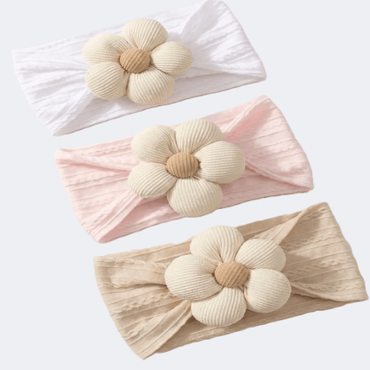 Three headbands with floral designs in white, pink, and beige on a light gray background.