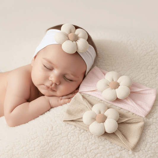 Three floral headbands in beige, pink, and white on a light background with a wooden bear toy and basket.