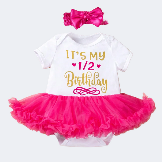 Baby outfit with pink tutu, white shirt, and pink headband on a white background